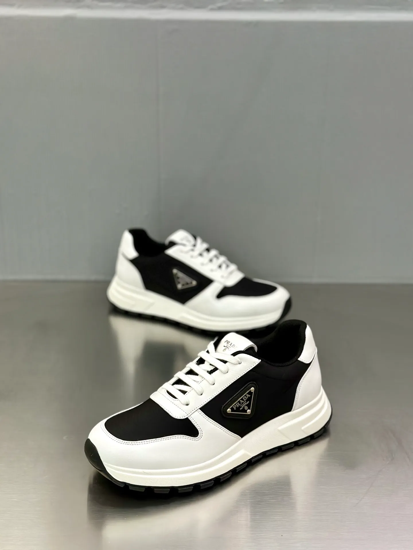 💰740 Prada/Prada men's new mesh stitching sneakers. This sneaker presents a modern version, reinterpreting the brand's archive style with clean lines and smooth details. The shoes are made of calf leather and technical fabric, with a triangular metal logo on the outside, bright TPU decoration on the heel, and a longer and padded inner heel design for a more comfortable fit. The tongue is decorated with a silk-screen logo, and is paired with a hollow rubber sole on the heel. The full cowhide lining comes standard with logo cowhide foot pads, making the upper foot taller, more comfortable, and versatile! Comes with full original packaging! Size: 39-40-41-42-43-44 standard leather shoe size (45 can be customized and does not support returns)